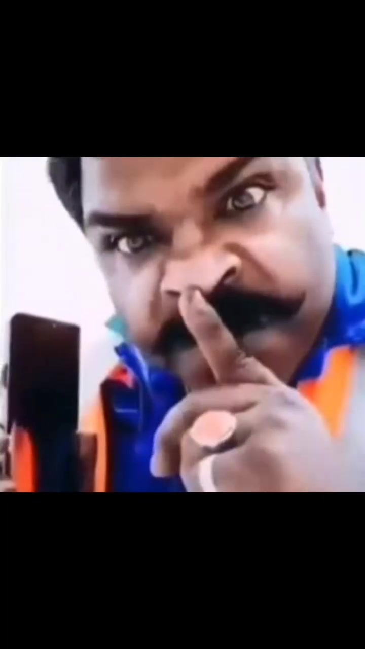 Mustachioed man shushing on the phone