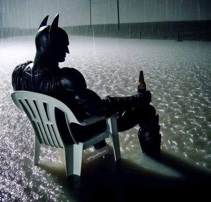 Batman sitting in the rain with a beer